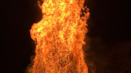 A large orange bonfire burning at night.