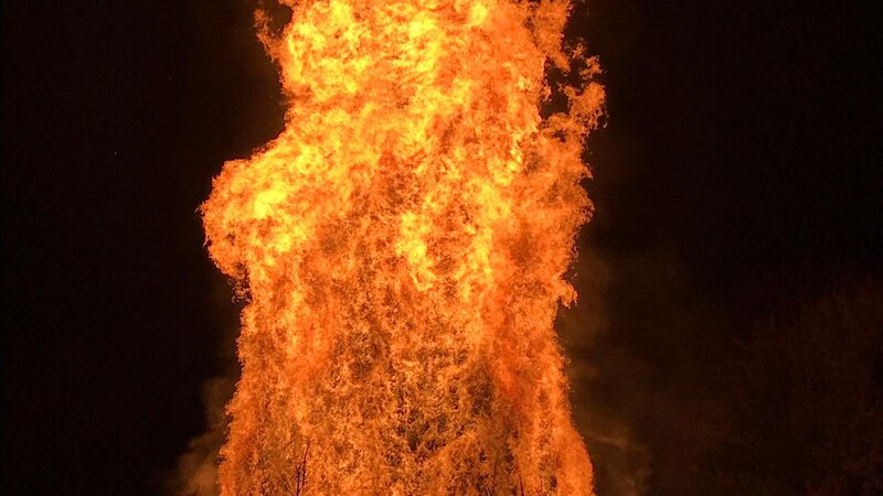 A large orange bonfire burning at night.