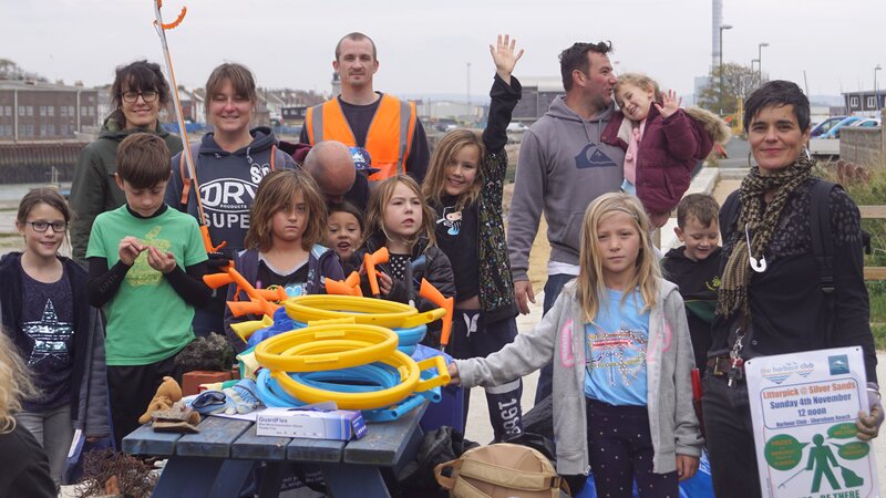 A group of adults and children littering picking