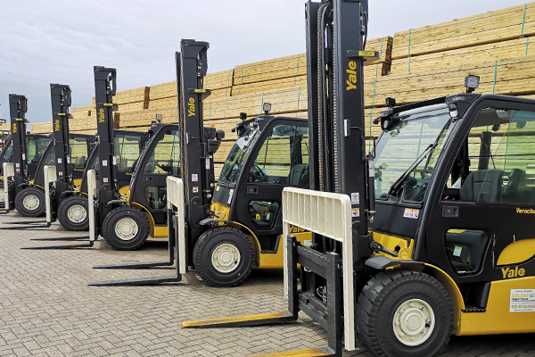 A row of yellow and black forklifts.