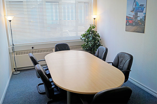 The Maritime House meeting room. It shows a wooden table with conference chairs.